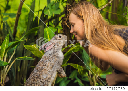 Woman holding a rabbit. Cosmetics test on rabbit animal. Cruelty free and stop animal abuse concept Woman holding a rabbit. Cosmetics test on rabbit animal. Cruelty free and stop animal abuse concept 57172720