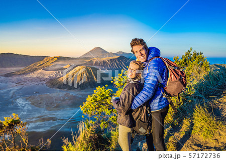 Young couple man and woman meet the sunrise at the Bromo Tengger Semeru National Park on the Java 57172736