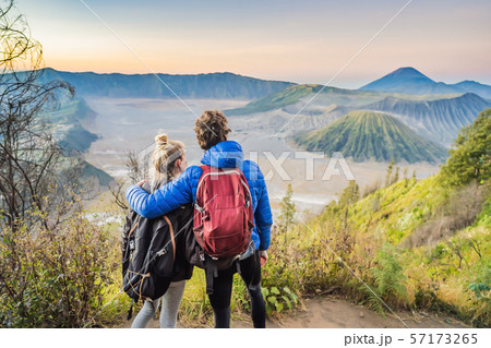Young couple man and woman meet the sunrise at the Bromo Tengger Semeru National Park on the Java Young couple man and woman meet the sunrise at the Bromo Tengger Semeru National Park on the Java 57173265