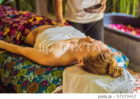 Young beautiful relaxing woman getting spa massage of shoulder in beauty salon Young beautiful relaxing woman getting spa massage of shoulder in beauty salon 57173417