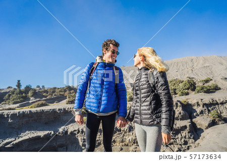 Young couple man and woman visit the Bromo volcano at the Tengger Semeru National Park on the Java Young couple man and woman visit the Bromo volcano at the Tengger Semeru National Park on the Java 57173634