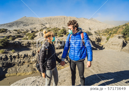 Young couple man and woman visit the Bromo volcano at the Tengger Semeru National Park on Java 57173649