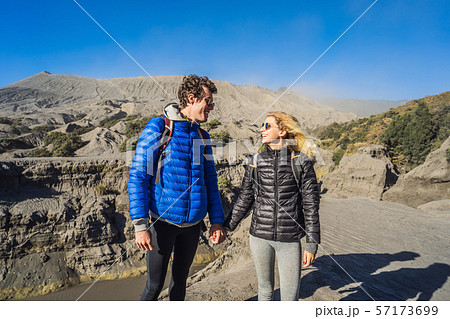 Young couple man and woman visit the Bromo volcano at the Tengger Semeru National Park on the Java Young couple man and woman visit the Bromo volcano at the Tengger Semeru National Park on the Java 57173699