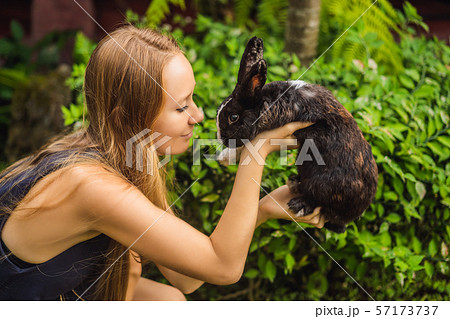 Woman holding a rabbit. Cosmetics test on rabbit animal. Cruelty free and stop animal abuse concept Woman holding a rabbit. Cosmetics test on rabbit animal. Cruelty free and stop animal abuse concept 57173737