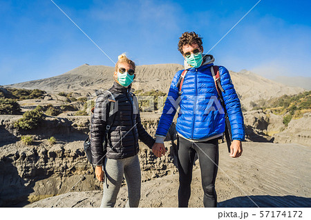 Young couple man and woman visit the Bromo volcano at the Tengger Semeru National Park on Java 57174172
