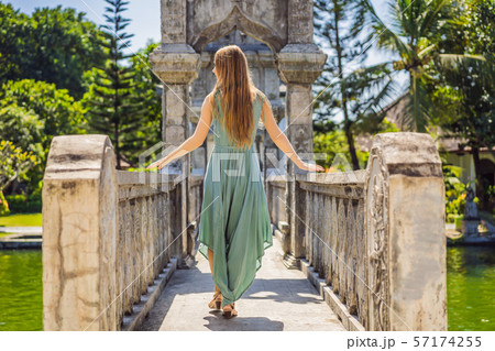 Young woman in dress in Water Palace Soekasada Taman Ujung Ruins on Bali Island in Indonesia 57174255