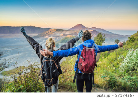 Young couple man and woman meet the sunrise at the Bromo Tengger Semeru National Park on the Java Young couple man and woman meet the sunrise at the Bromo Tengger Semeru National Park on the Java 57174367