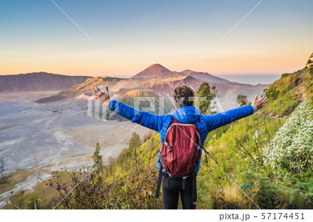 Young man meets the sunrise at the Bromo Tengger Semeru National Park on the Java Island, Indonesia Young man meets the sunrise at the Bromo Tengger Semeru National Park on the Java Island, Indonesia 57174451