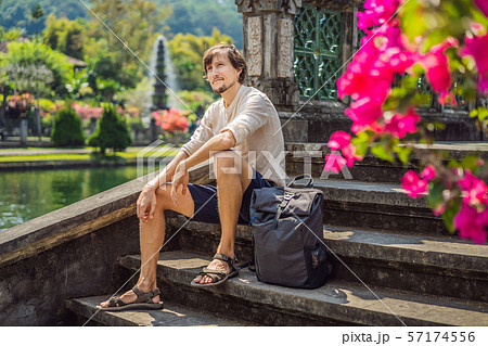 Young man tourist in Taman Tirtagangga, Water palace, Water park, Bali Indonesia Young man tourist in Taman Tirtagangga, Water palace, Water park, Bali Indonesia 57174556