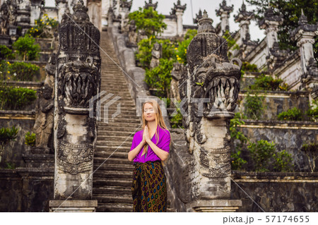 Young woman tourist on background of Three stone ladders in beautiful Pura Lempuyang Luhur temple Young woman tourist on background of Three stone ladders in beautiful Pura Lempuyang Luhur temple 57174655