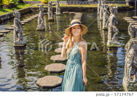 Young woman tourist in Taman Tirtagangga, Water palace, Water park, Bali Indonesia Young woman tourist in Taman Tirtagangga, Water palace, Water park, Bali Indonesia 57174767