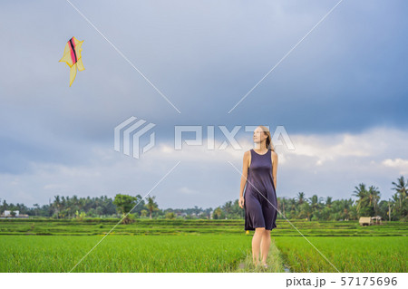 Young woman tourist launches a kite in a rice field in Ubud, Bali Island, Indonesia 57175696