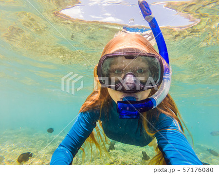 Happy woman in snorkeling mask dive underwater with tropical fishes in coral reef sea pool. Travel Happy woman in snorkeling mask dive underwater with tropical fishes in coral reef sea pool. Travel 57176080