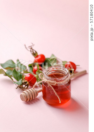 Fresh rose hip berries and honey on pink 57180410