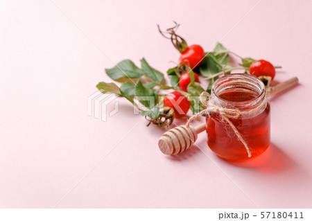Fresh rose hip berries and honey on pink 57180411