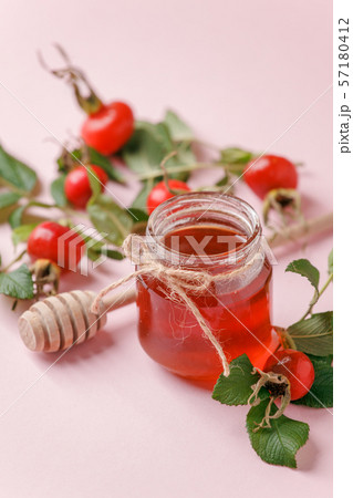 Fresh rose hip berries and honey on pink 57180412