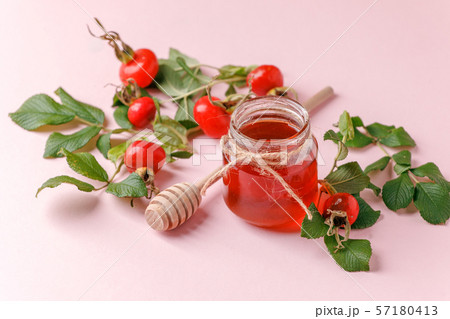 Fresh rose hip berries and honey on pink 57180413