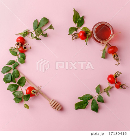 Fresh rose hip berries and honey on pink 57180416