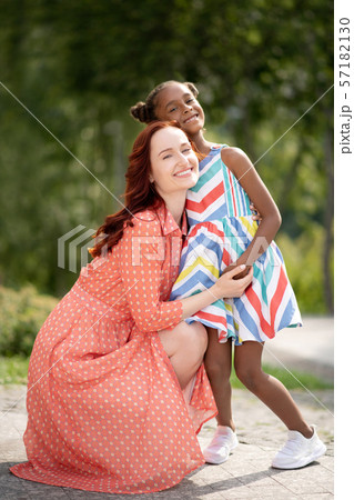 Beaming dark-skinned daughter hugging her loving mom 57182130