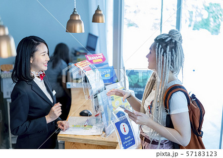 訪日観光客に笑顔で応対する女性観光ガイド受付嬢 57183123