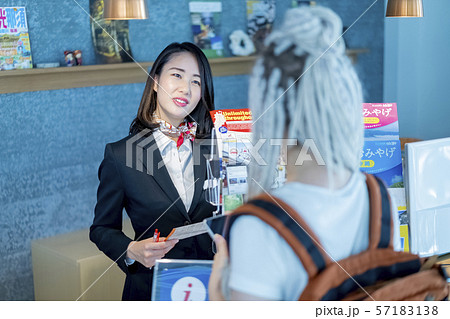 外国人向け観光案内所で丁寧な言葉遣いや気遣いをする華やかな女性スタッフ 57183138