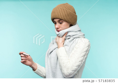 Young woman having flue taking thermometer against 57183835