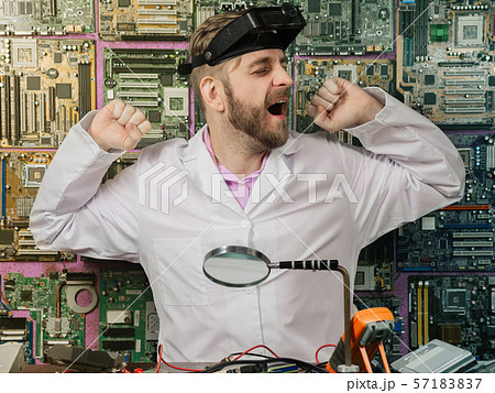 Young male electrician engineer tiredly yawns Young male electrician engineer tiredly yawns 57183837