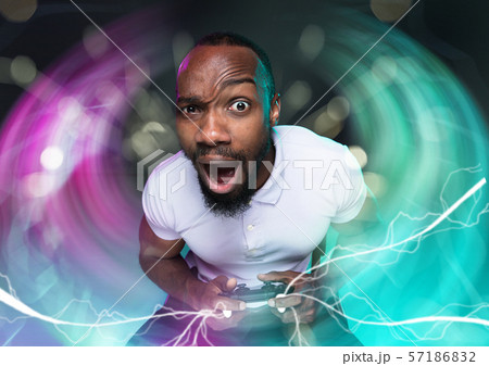 Enthusiastic gamer. Joyful young man holding a video game controller Enthusiastic gamer. Joyful young man holding a video game controller 57186832