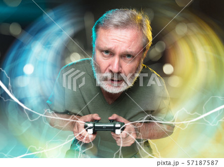 Enthusiastic gamer. Joyful man holding a video game controller Enthusiastic gamer. Joyful man holding a video game controller 57187587
