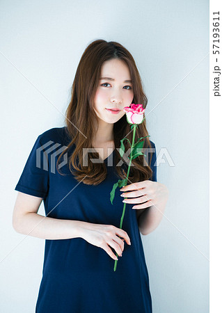 一輪の薔薇を持つ若い女性の写真素材