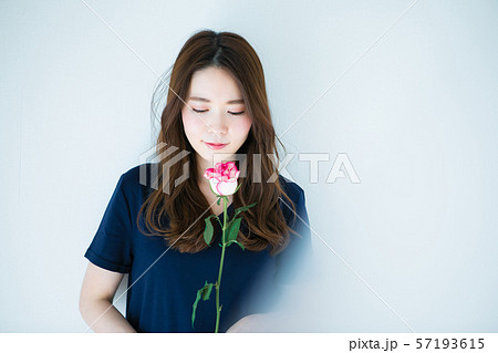 一輪の薔薇を持つ若い女性 57193615