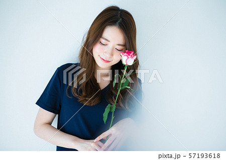 一輪の薔薇を持つ若い女性の写真素材