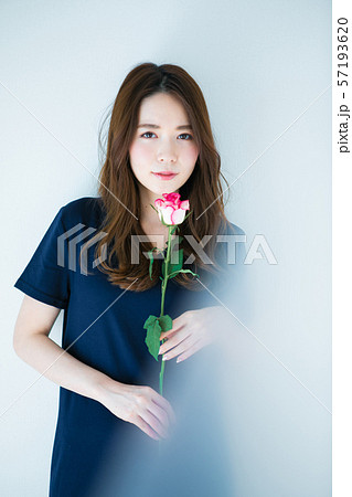 一輪の薔薇を持つ若い女性の写真素材