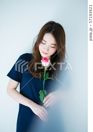 一輪の薔薇を持つ若い女性 57193621