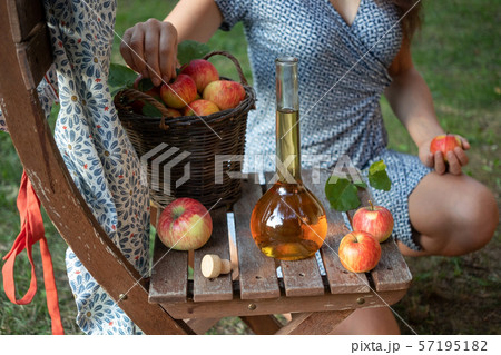 A bottle of apple cider vinegar with fresh apples A bottle of apple cider vinegar with fresh apples 57195182
