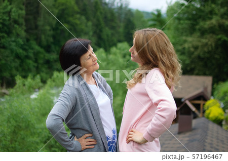 Outdoors portrait of happy mother and daughter looking to each other spending time together outside Outdoors portrait of happy mother and daughter looking to each other spending time together outside 57196467