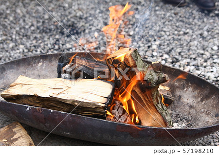Burning wood of campfire in metal fire bowl on a pebble floor 57198210