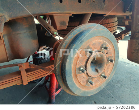 Closeup of a car rim without a tire jacking up for raising the axle of a motor vehicle off the ground so that a wheel can be changed - vehicle tire replacement and maintenance concept 57202386