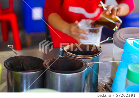 Woman's hands preparing traditional iced coffee cup - traditional coffee drink - fresh coffee drink preparation Woman's hands preparing traditional iced coffee cup - traditional coffee drink - fresh coffee drink preparation 57202391