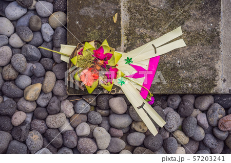 Traditional balinese offerings to gods in Bali with flowers and aromatic sticks 57203241