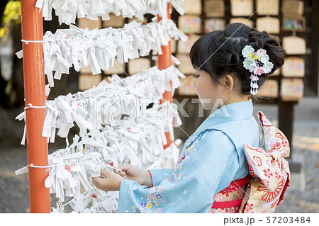 神社でおみくじを結ぶ着物姿の女の子 57203484