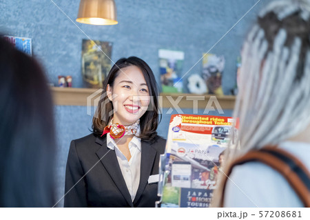 訪日外国人旅行者に丁寧な言葉遣いでおもてなし笑顔の女性観光ガイド受付嬢 57208681
