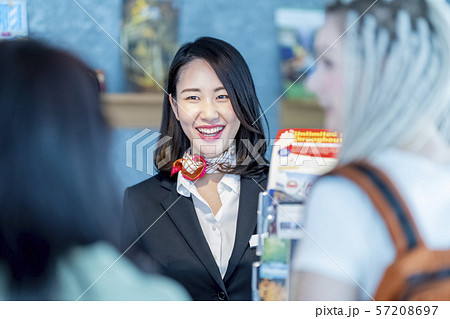 外国人向け観光案内所で訪日外国人旅行者インバウンドに日本全国の観光名所案内をする女性 57208697