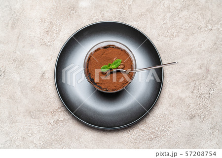 Portion of Classic tiramisu dessert in a glass cup on concrete background 57208754