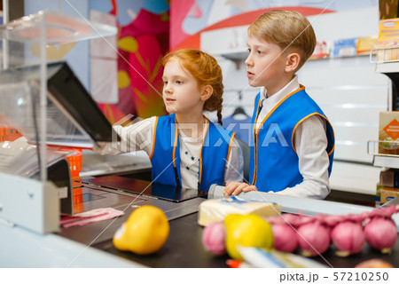 Girl and boy in uniform at the register, sellers 57210250
