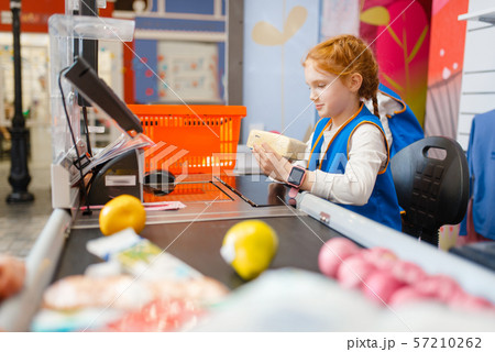Girl in uniform at the register playing seller 57210262