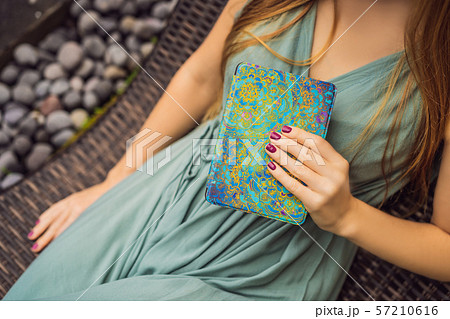 Woman reads e-book on deck chair in the garden 57210616