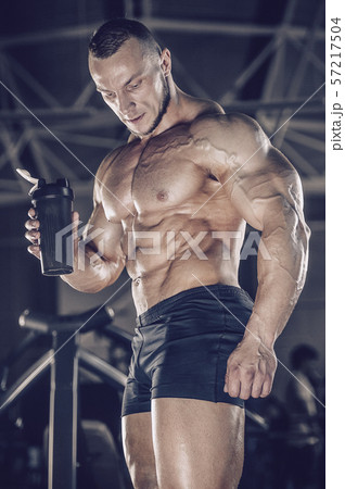 Brutal strong men workout bodybuilding background - muscular bodybuilder men doing exercises in gym 57217504