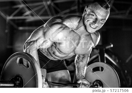Brutal strong men workout bodybuilding background - muscular bodybuilder men doing exercises in gym 57217506