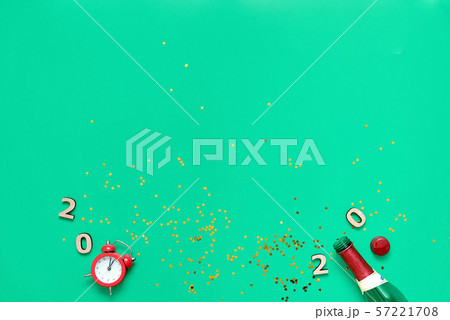 Champagne bottle, glitter, alarm clock and 2020 text. Flat lay of new year, christmas eve Champagne bottle, glitter, alarm clock and 2020 text. Flat lay of new year, christmas eve 57221708